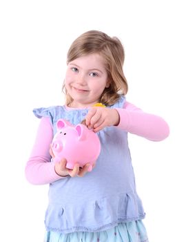 young girl dropping money into a pink piggy bank isolated on white background