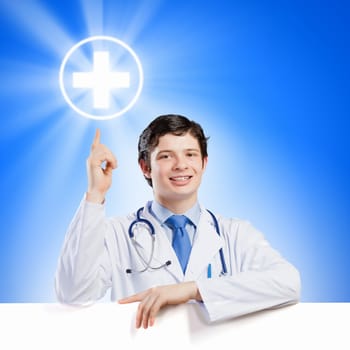 Young smiling doctor with blank banner. Place for text