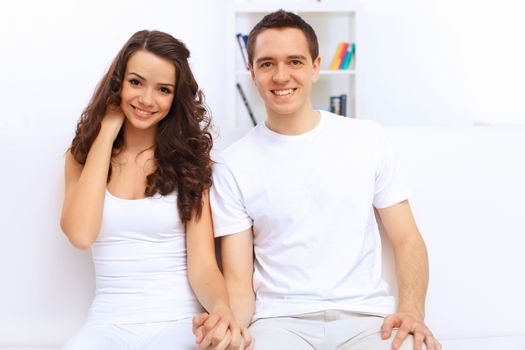 Young happy couple at hone together sitting and talking