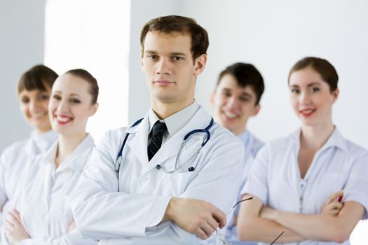 Young doctor in uniform and colleagues at background