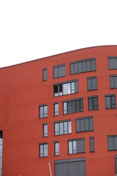 Exterior of a red commercial building with windows and a flat roof with copyspace