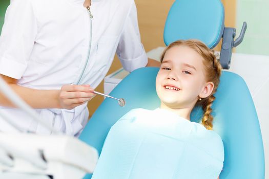 Little girl sitting in the dentists office