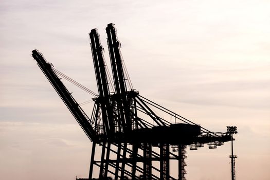silhouette of Cargo crane at Terminal port during sunset
