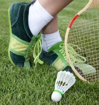 foot of sportswoman who plays badminton on grass