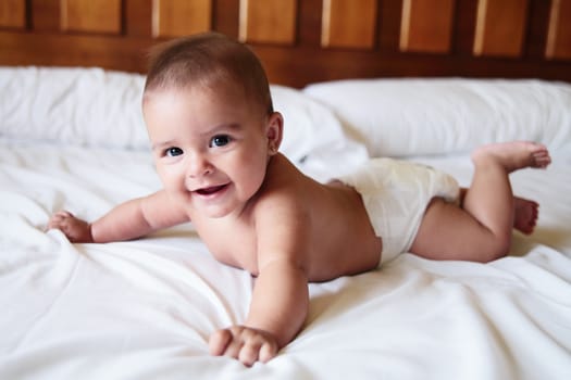 a beautiful smiling baby on a bed