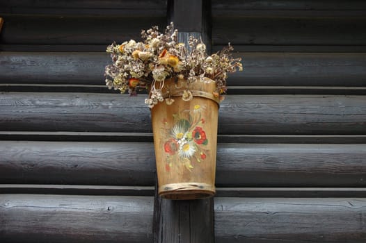 Wooden and painted plant pot on wooden wall