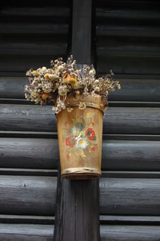 Wooden and painted plant pot on wooden wall