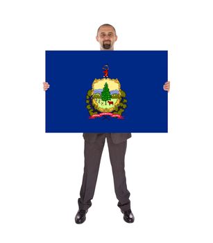 Smiling businessman holding a big card, flag of Vermont, isolated on white