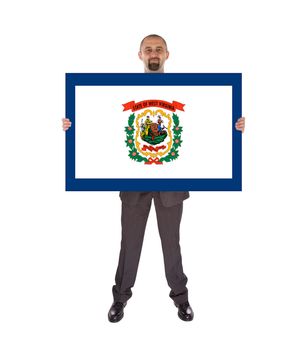 Smiling businessman holding a big card, flag of West Virginia, isolated on white