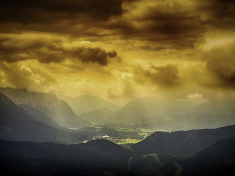 View from the mountain named Herzogstand to alps, village and dark storm clouds, Bavaria, Germany