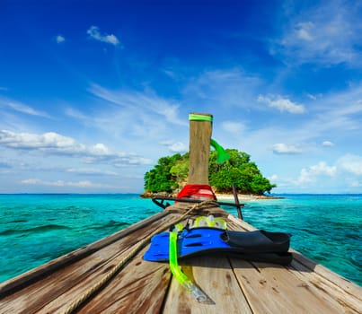 Vacation holidays adventure  concept background - tropical island and long-tail boat  with snorkeling set. Thailand