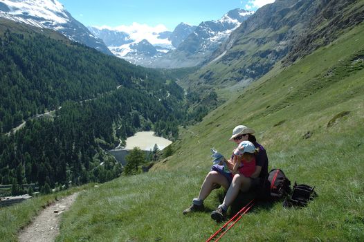 Mother and daughter on trail in mountains nearby Matterhorn peak in Switzerland