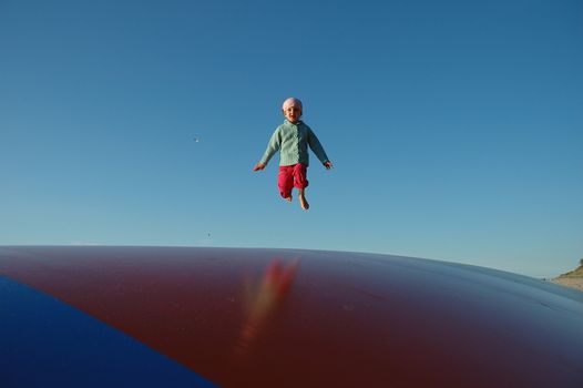 Child jumping on big trampoline / baloon