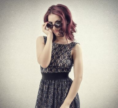 Red hair women looking through glasses at camera