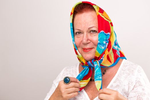 Old lady giving a happy satisfied look in her colorful headscarf