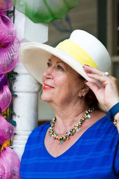 Beautiful matured woman wearing hat and blue dress in a close up shot