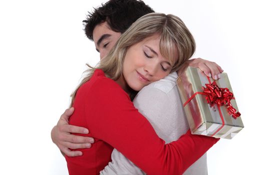 young man holding girlfriend in arms after giving present