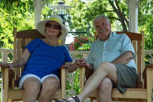 Retired Couple Resting in the Gazebo while holding each others hands