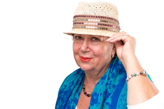 Senior woman posing with her fancy straw hat, she has blue color scarf on her shoulders