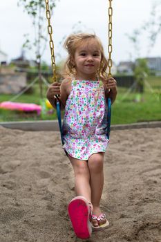 Little girl posing on the swing in a very natural way
