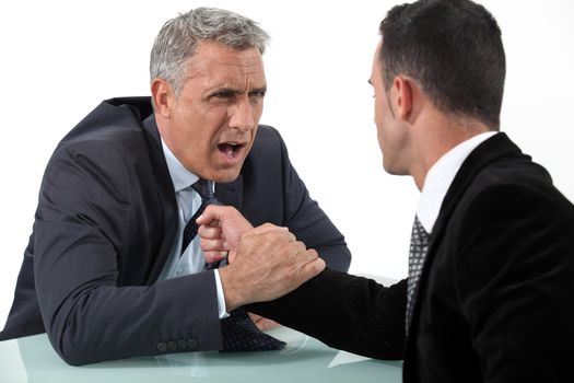 Businessmen fighting at desk