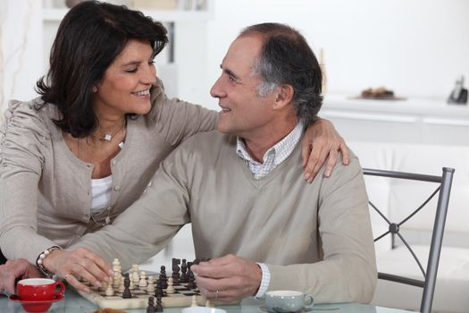 Married couple playing chess at home