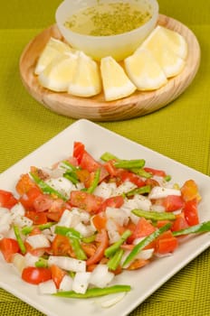 Fresh salad with a spicy lemon dressng in the background