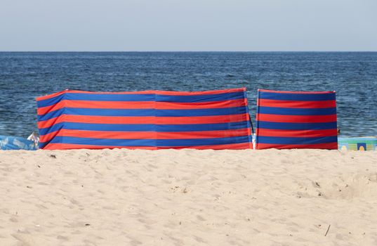 Red and blue striped windbreak at the beach