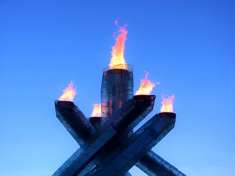 Contemporary fire torches burning over a cloudless blue sky