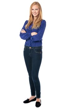Confident successful young woman in stylish smart casual clothing standing with folded arms smiling at the camera, full length on white