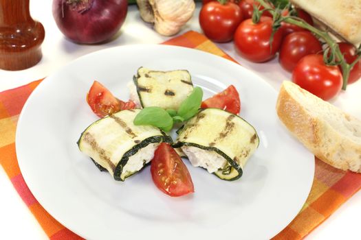 fresh stuffed zucchini rolls with cream cheese on a light background