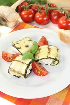 fresh delicious stuffed zucchini rolls with cream cheese on a light background