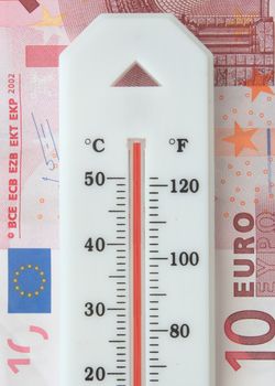 Overheated thermometer on top of a euro banknote 