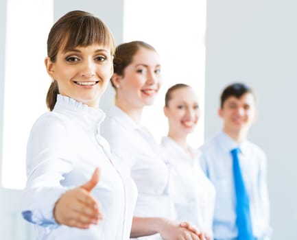 invitation to the team, business woman holds out her hand, her face a number of young businessmen