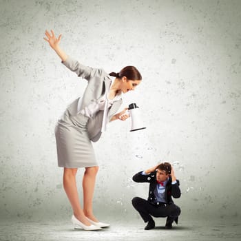 Angry businesswoman with megaphone shouting at colleague