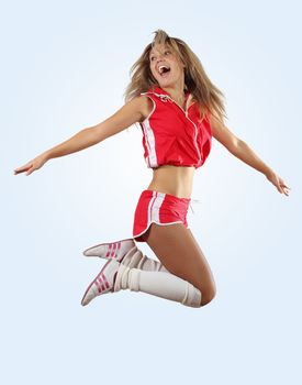 Uniformed cheerleader jumps high in the air isolated on white.