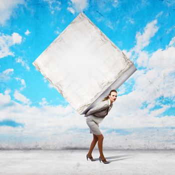 Image of businesswoman carrying big white cube on her back. Place for text