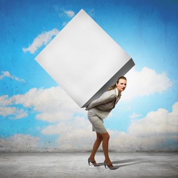 Image of businesswoman carrying big white cube on her back. Place for text