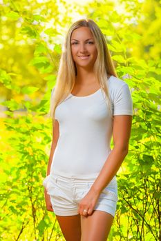 a beautiful blonde in a summer forest