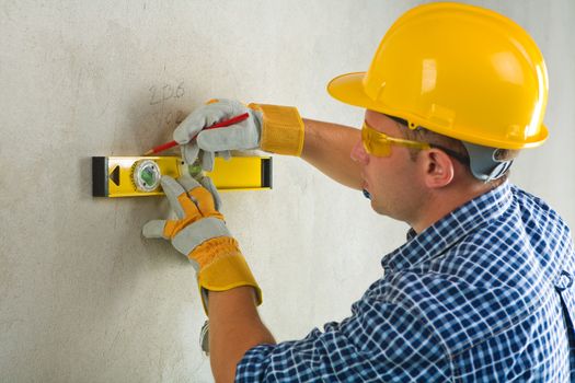 worker with construction level and pencil