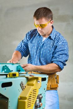 young men adjusts woodworking mashine