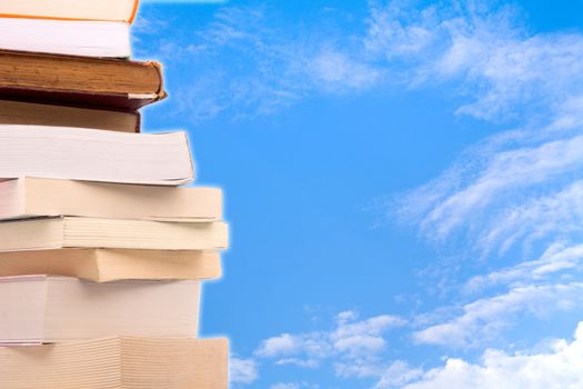 Old books in a stack with sky background