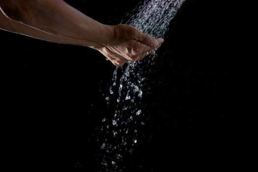 hand and pouring water splashing  on black background  for multipurpose