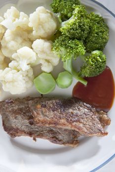 fried beef  tomato ketchup and green Broccoli white flowering cabbage ready to eating