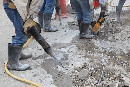 worker of road construction drilling cement ground