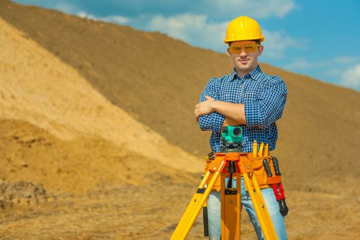 worker with theodolite on construction site