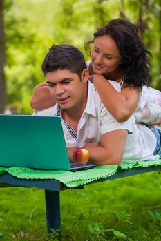 beautiful couple on bench with laptop