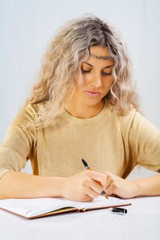 beautyful blonde wtiting with a ballpoint  pen