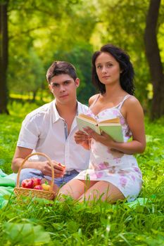 couple with book  looking at camera