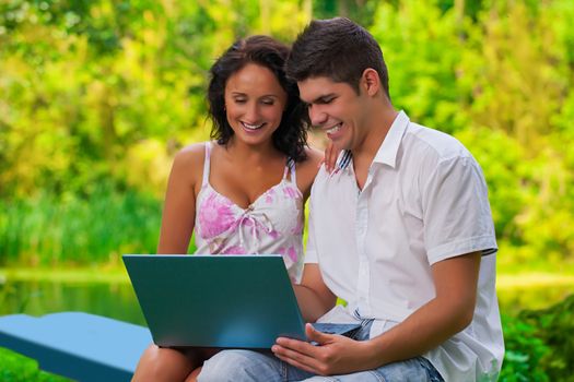 couple with laptop in park